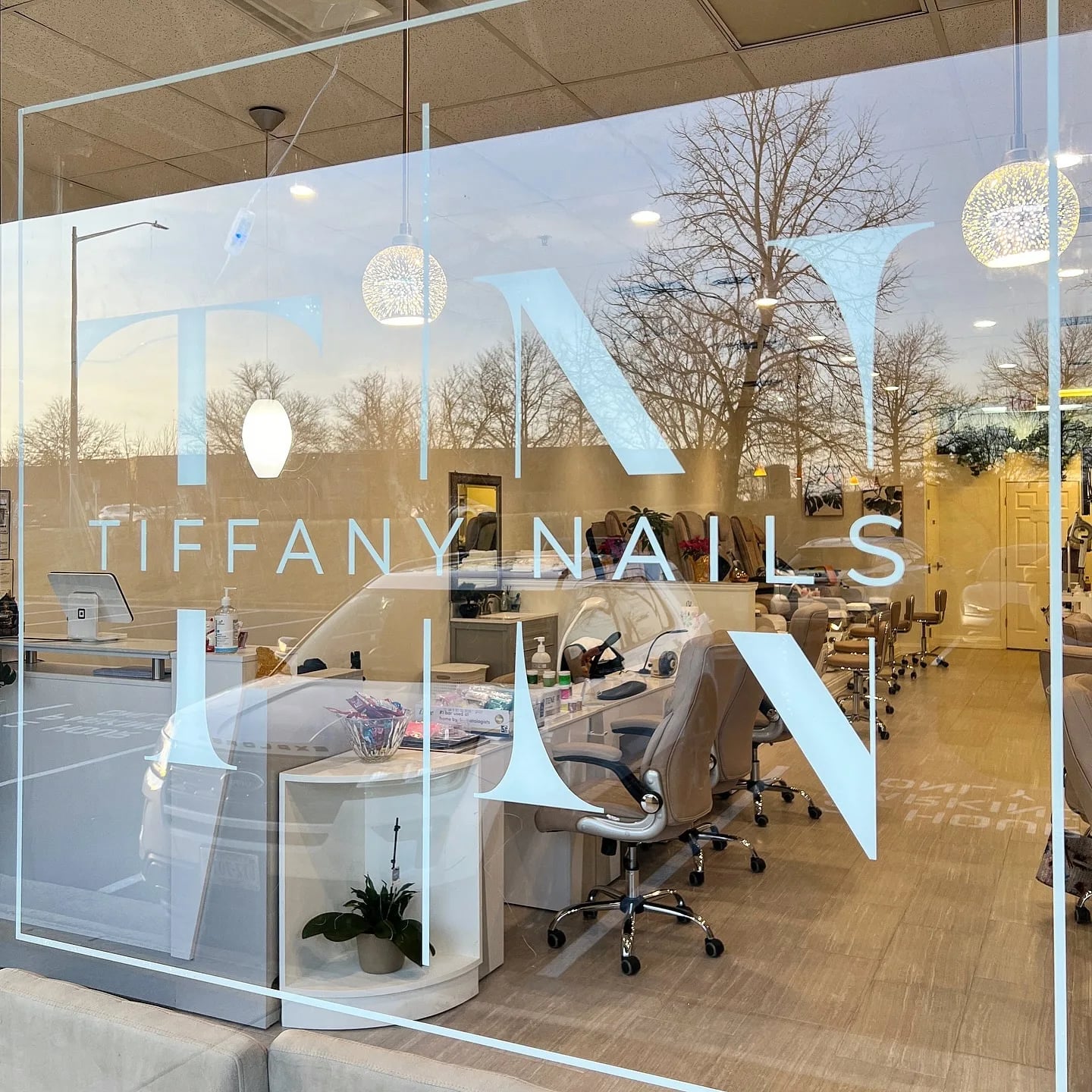 The salon storefront with the Tiffany Nails monogram on the window